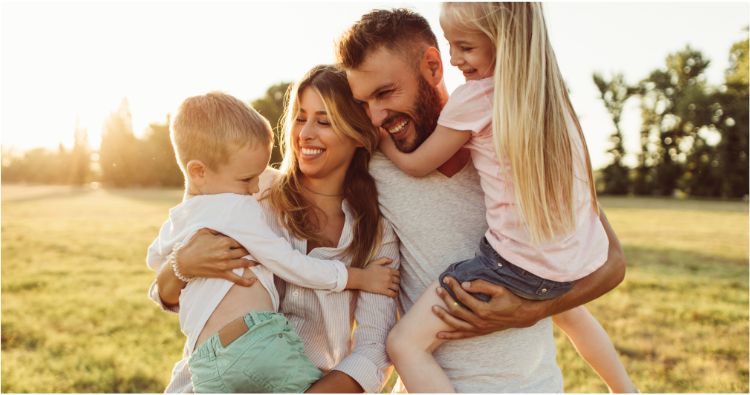 millennial family of 4 in out in a park.