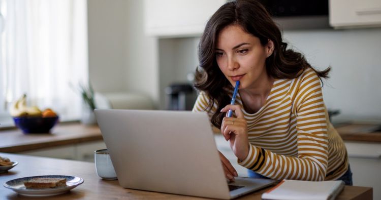 A middle-aged woman looks at her laptop