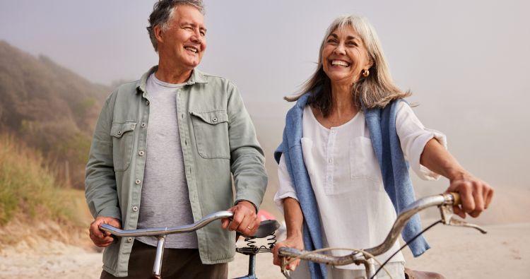A retirement-aged couple walk together in a park.