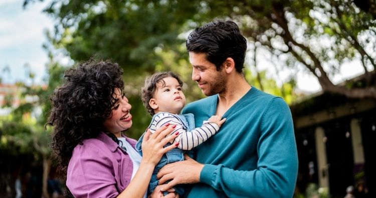 silver haired woman with green scarf, smiles on video call