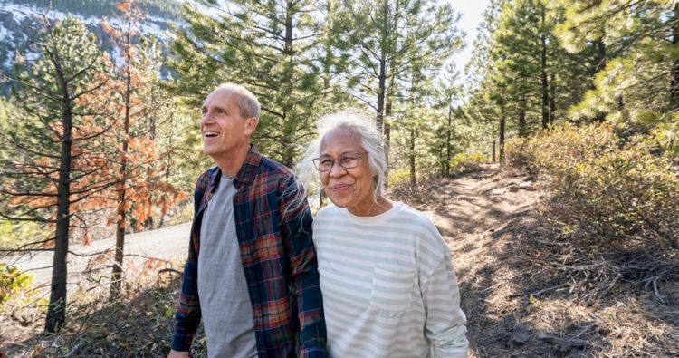 A retired couple walks in the woods together